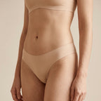 Demonstration of MemoSkin no-show lace briefs providing an invisible line-free look under tight clothing