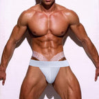 Front view of a model wearing white men’s lace jockstrap underwear